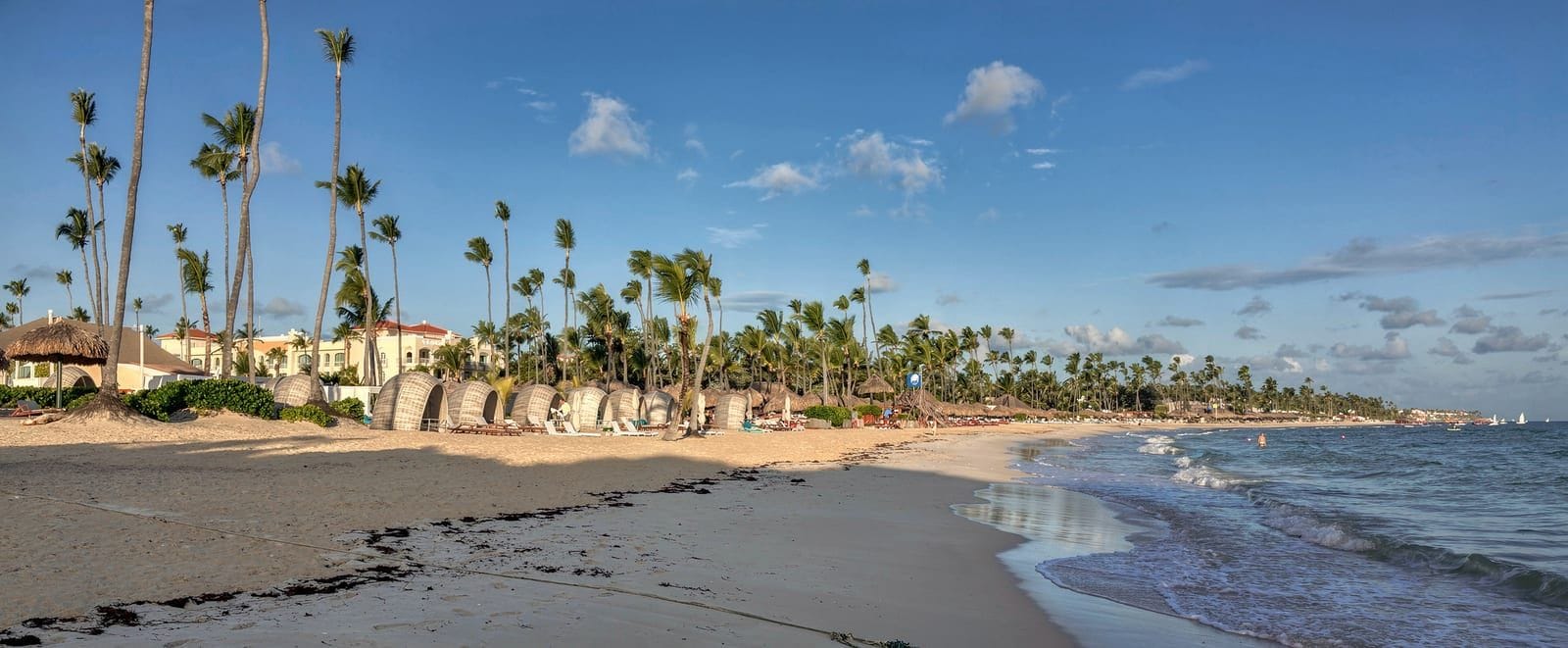 Aguas turquesas y palmeras en la playa de Bávaro al atardecer.